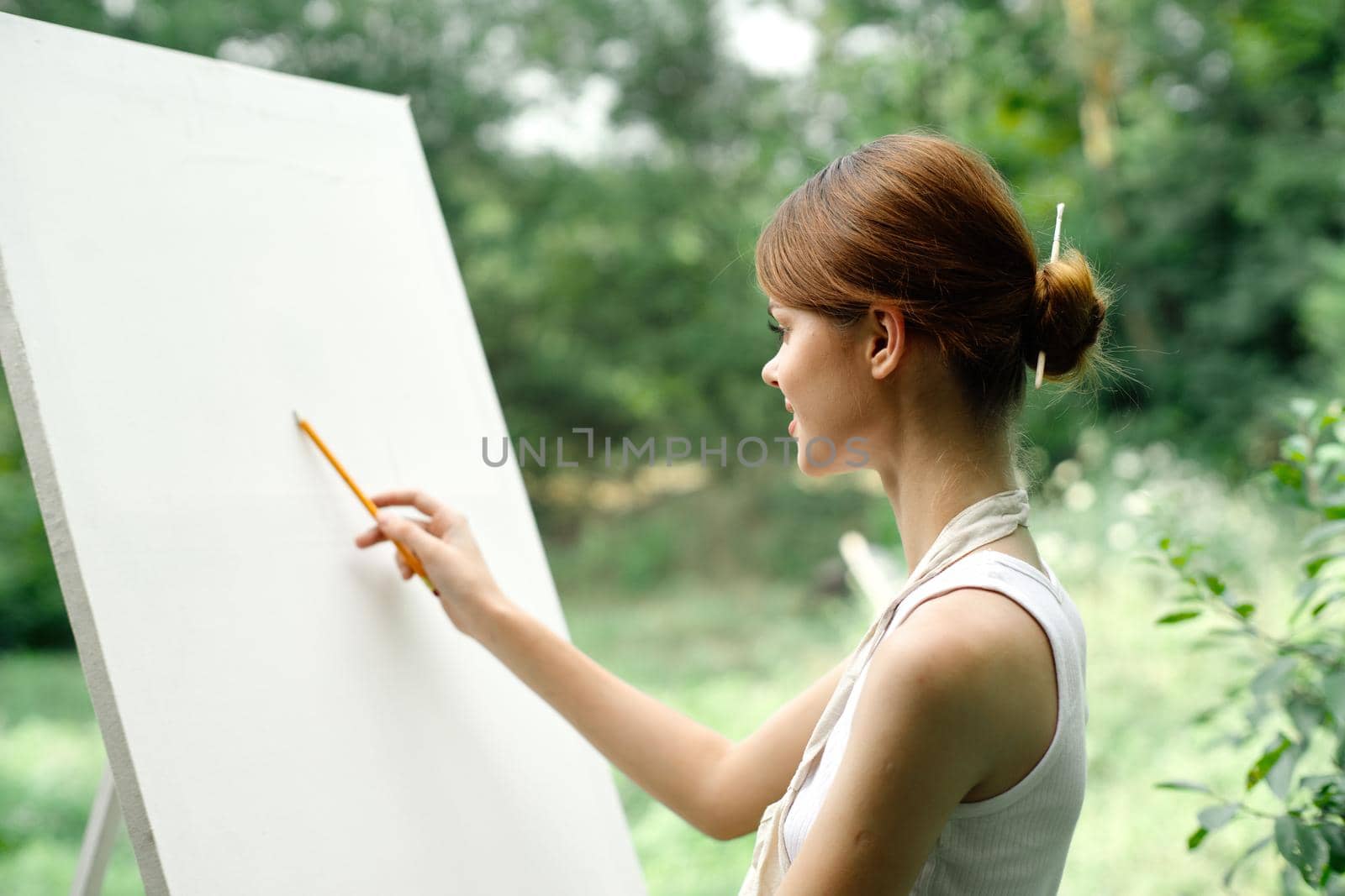 an artist in nature draws on an easel with a pencil. High quality photo