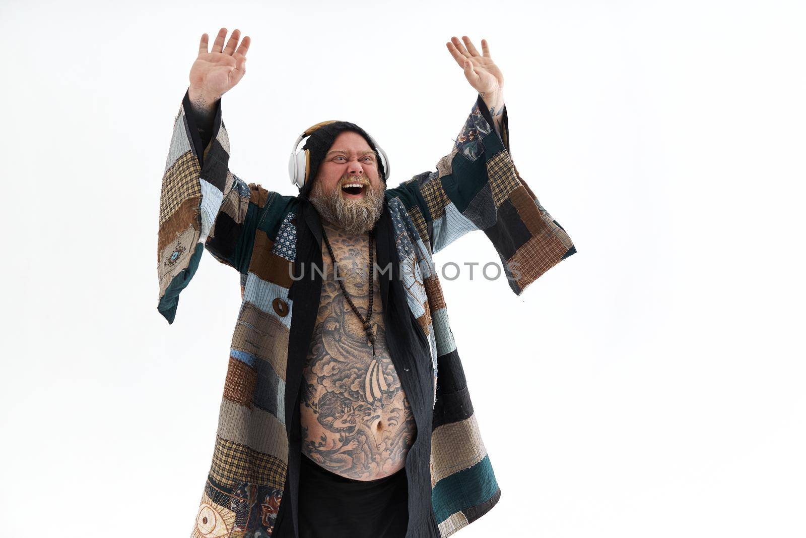 Fat stylish bearded tattoed caucasian man with big belly is posing and dancing wearing ethnic kimono by Yaroslav_astakhov