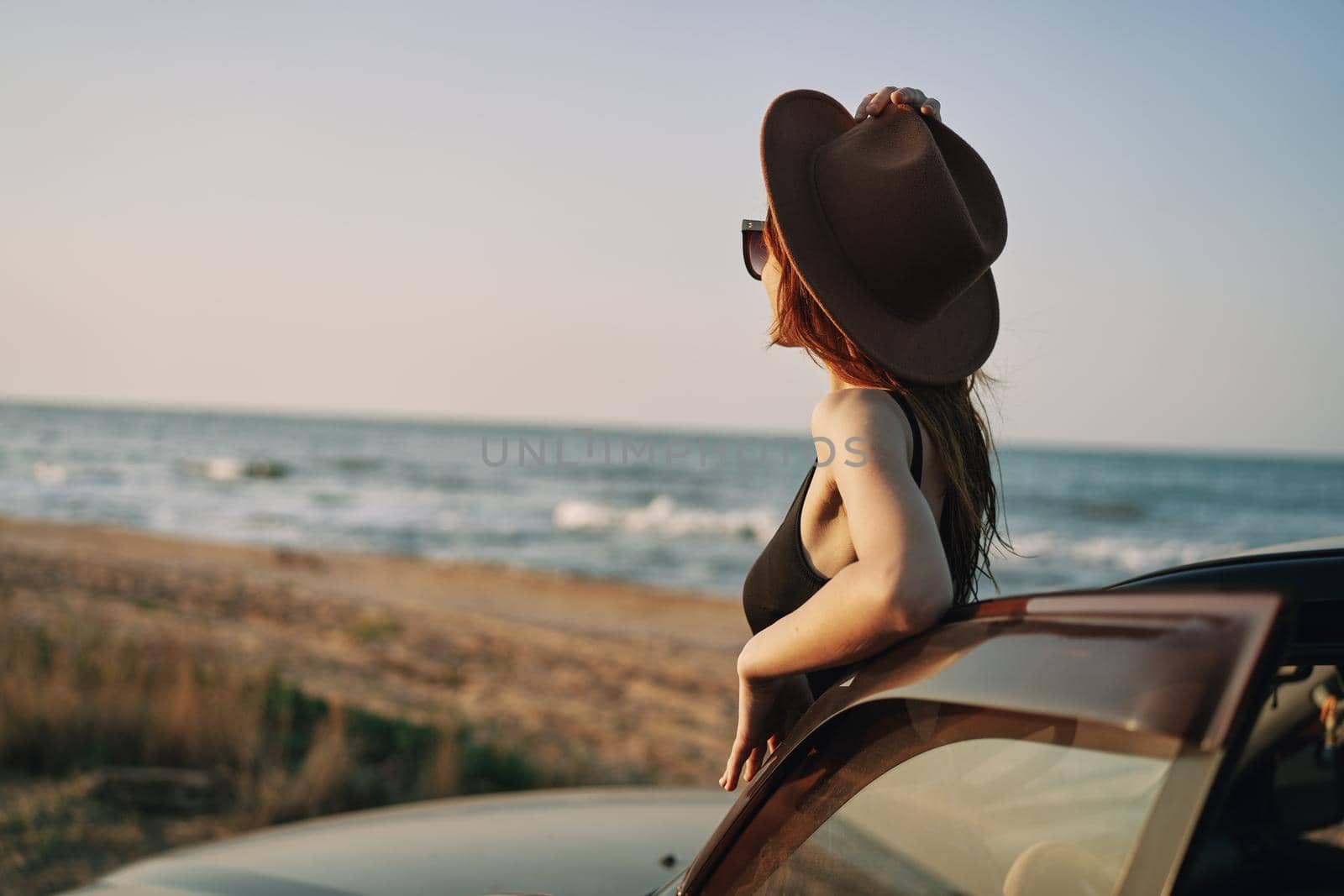 pretty woman in sunglasses near the car on the beach travel lifestyle. High quality photo