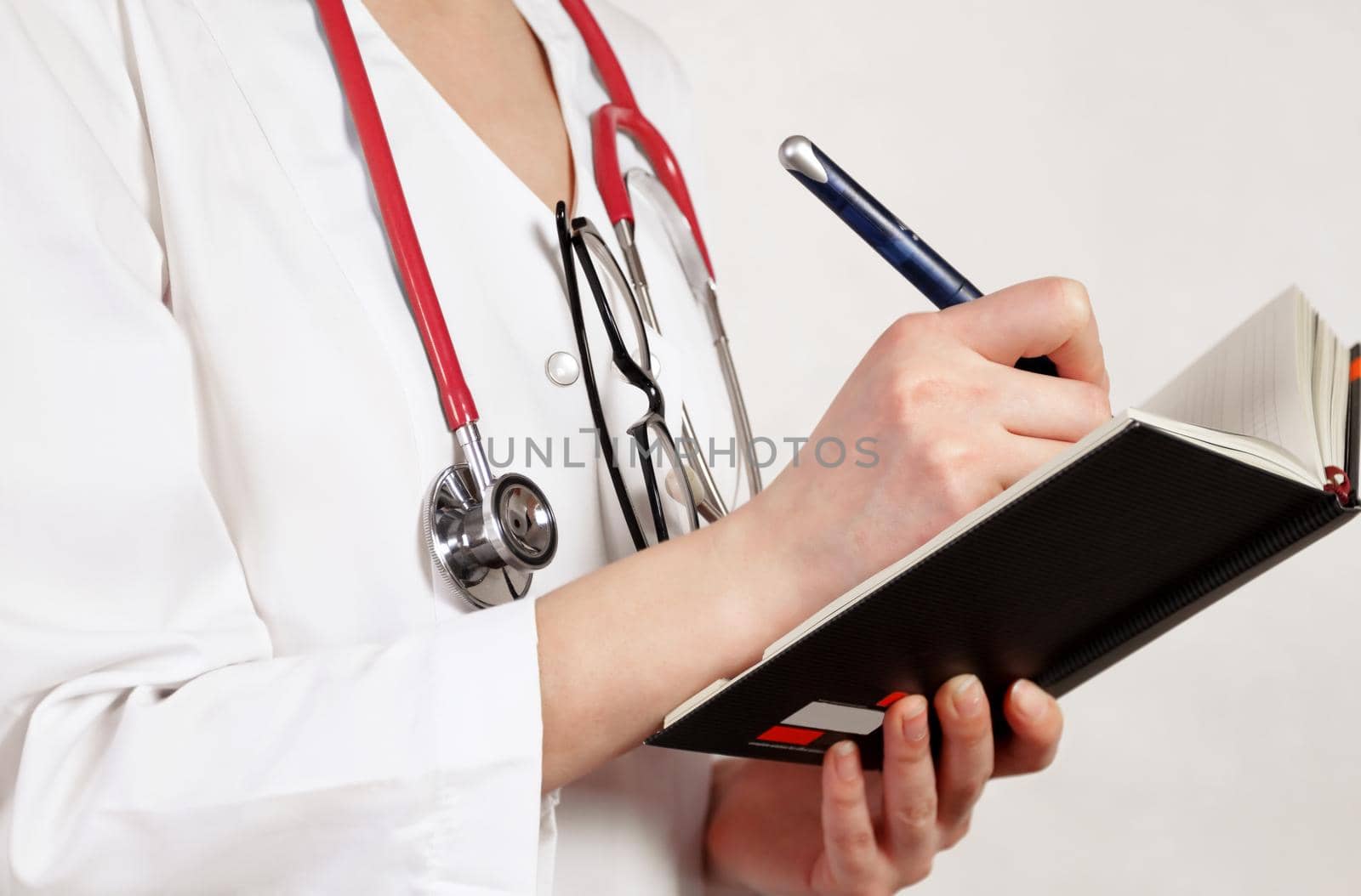 Doctor writes in working notebook