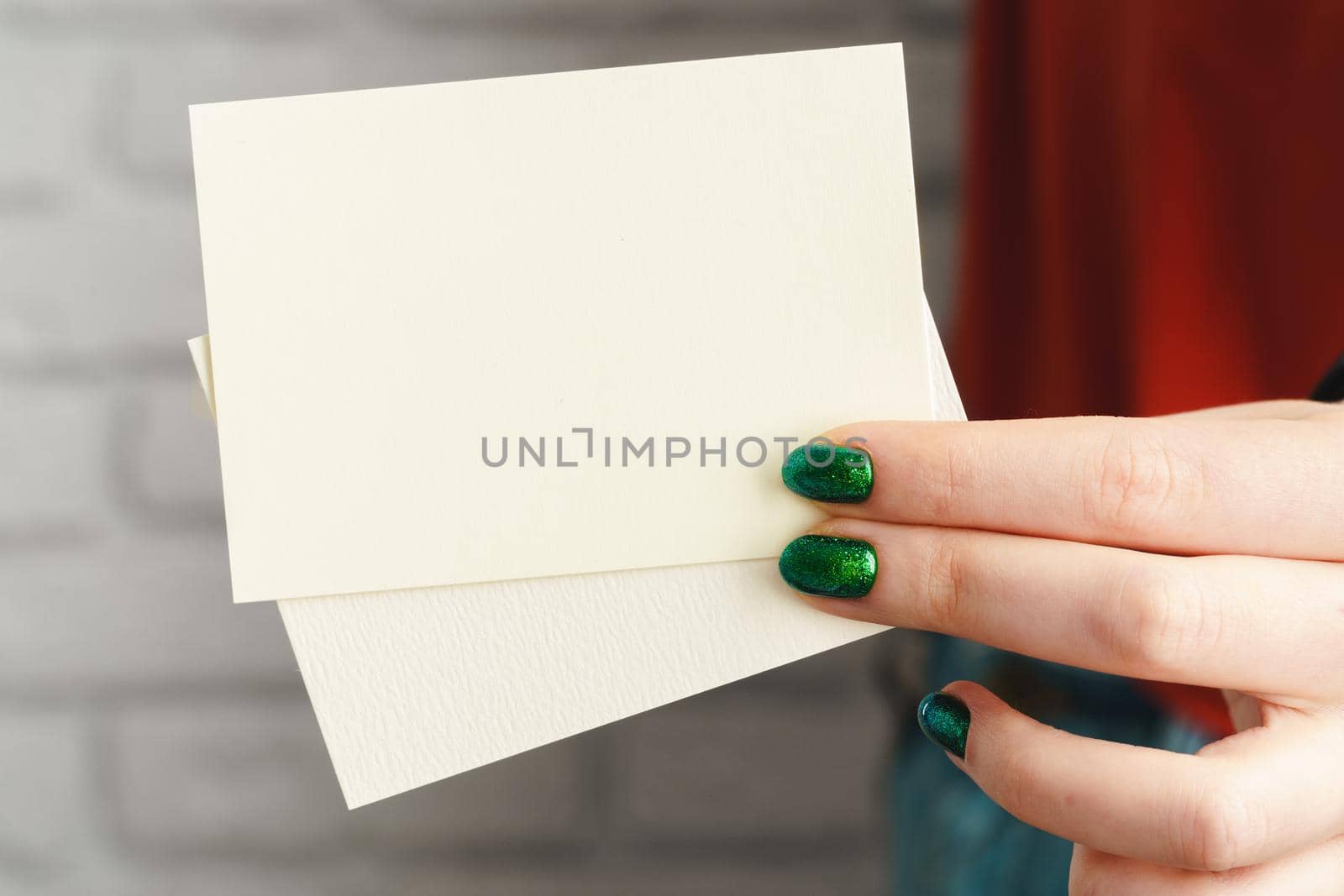 Girl's hand holding blank white business card close up