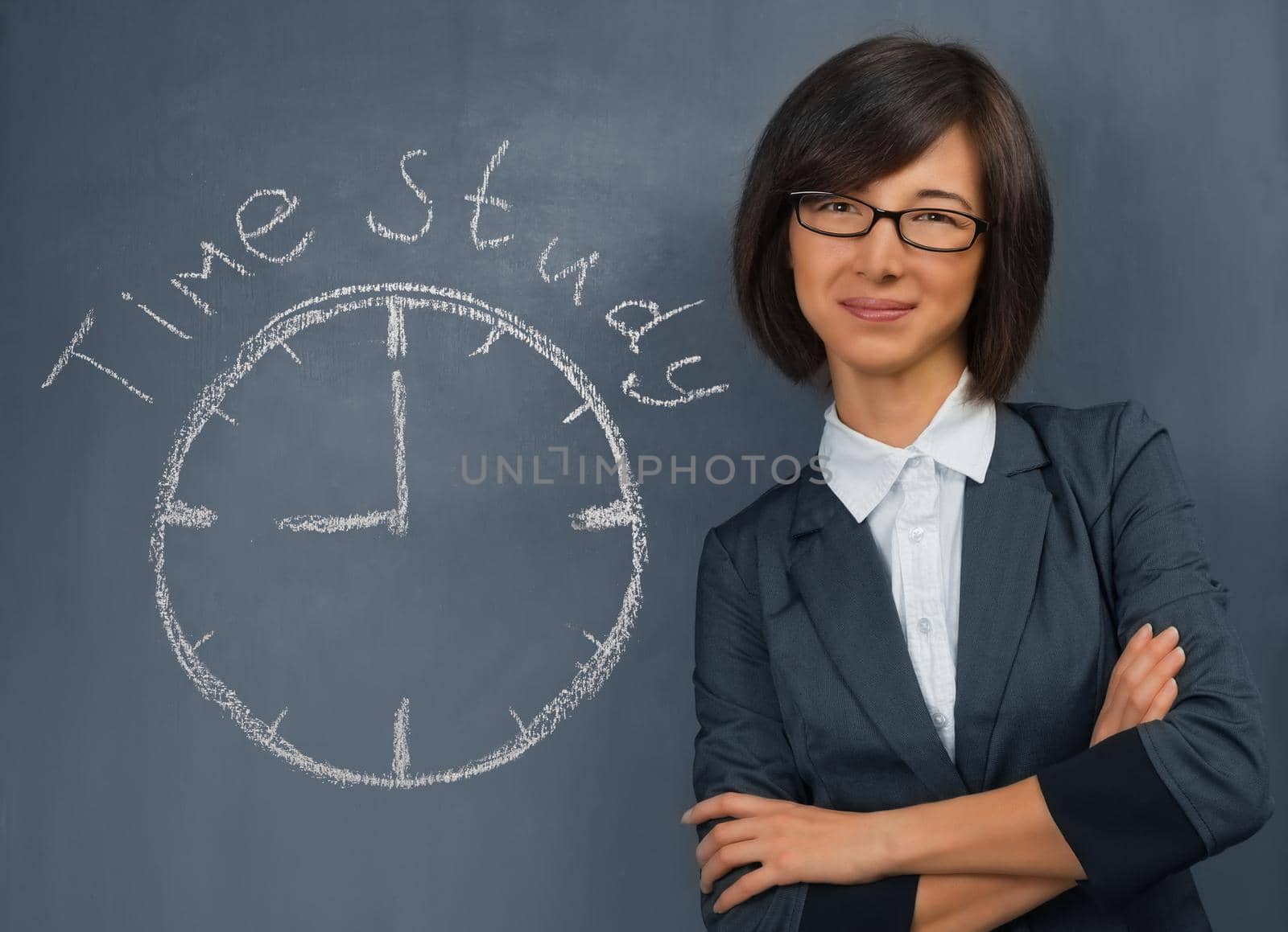 Young woman in a suit is standing near the blackboard, on which is written time study