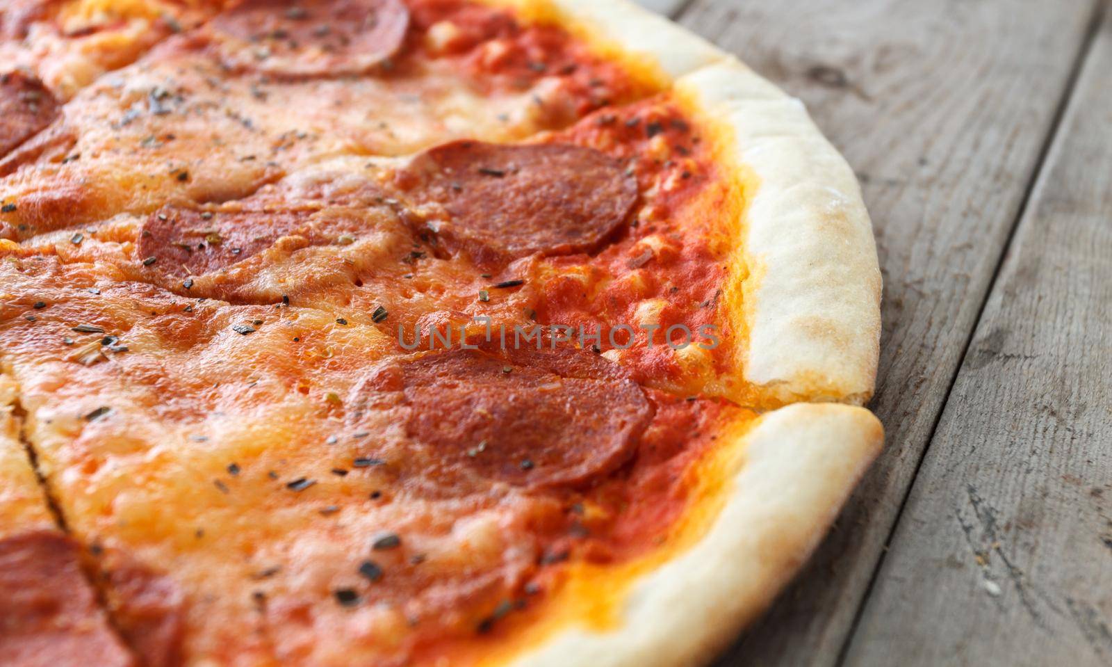Pepperoni pizza on a wooden table, close-up