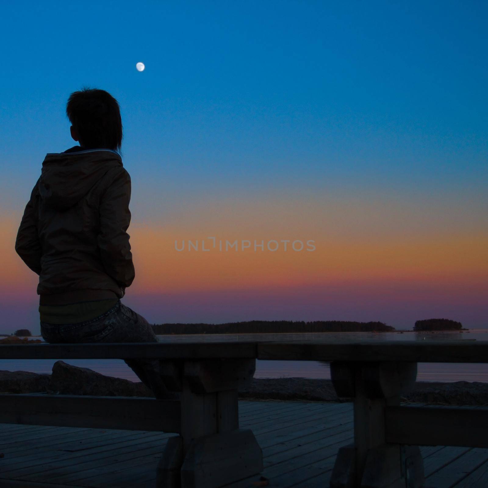 Woman enjoying the silence during a wonderful sunset by alexAleksei