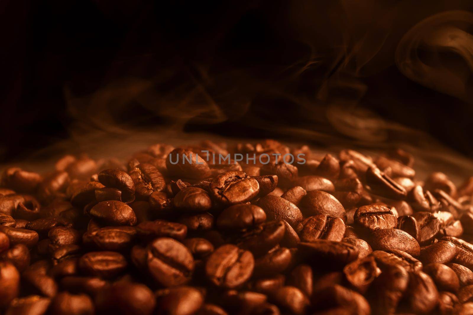Roasted coffee beans on a black background, close-up