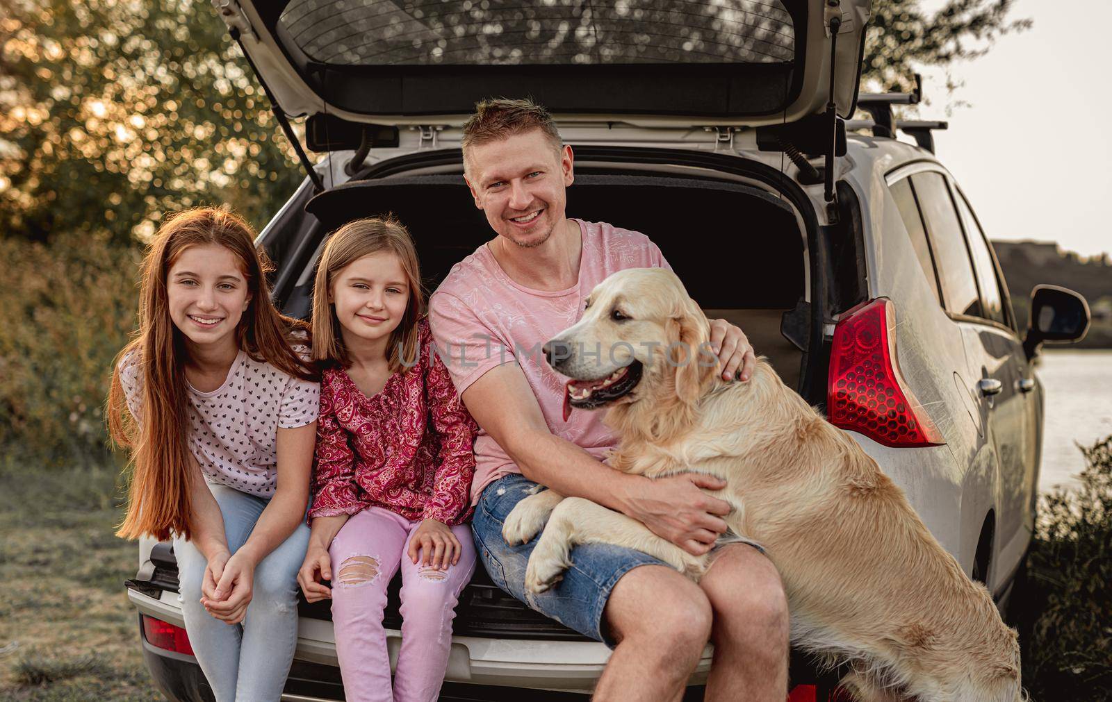 Family with dog next to open car by tan4ikk1