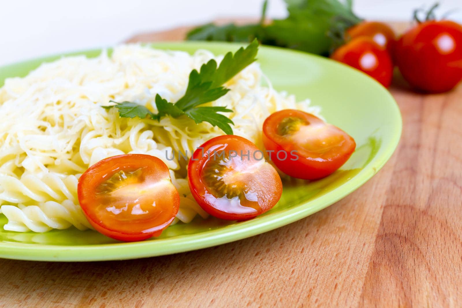 Macaroni and cheese, tomatoes on the green plate, side view