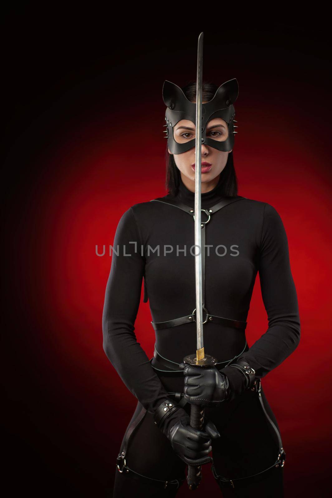 the woman in a black belt and cat mask with a katana