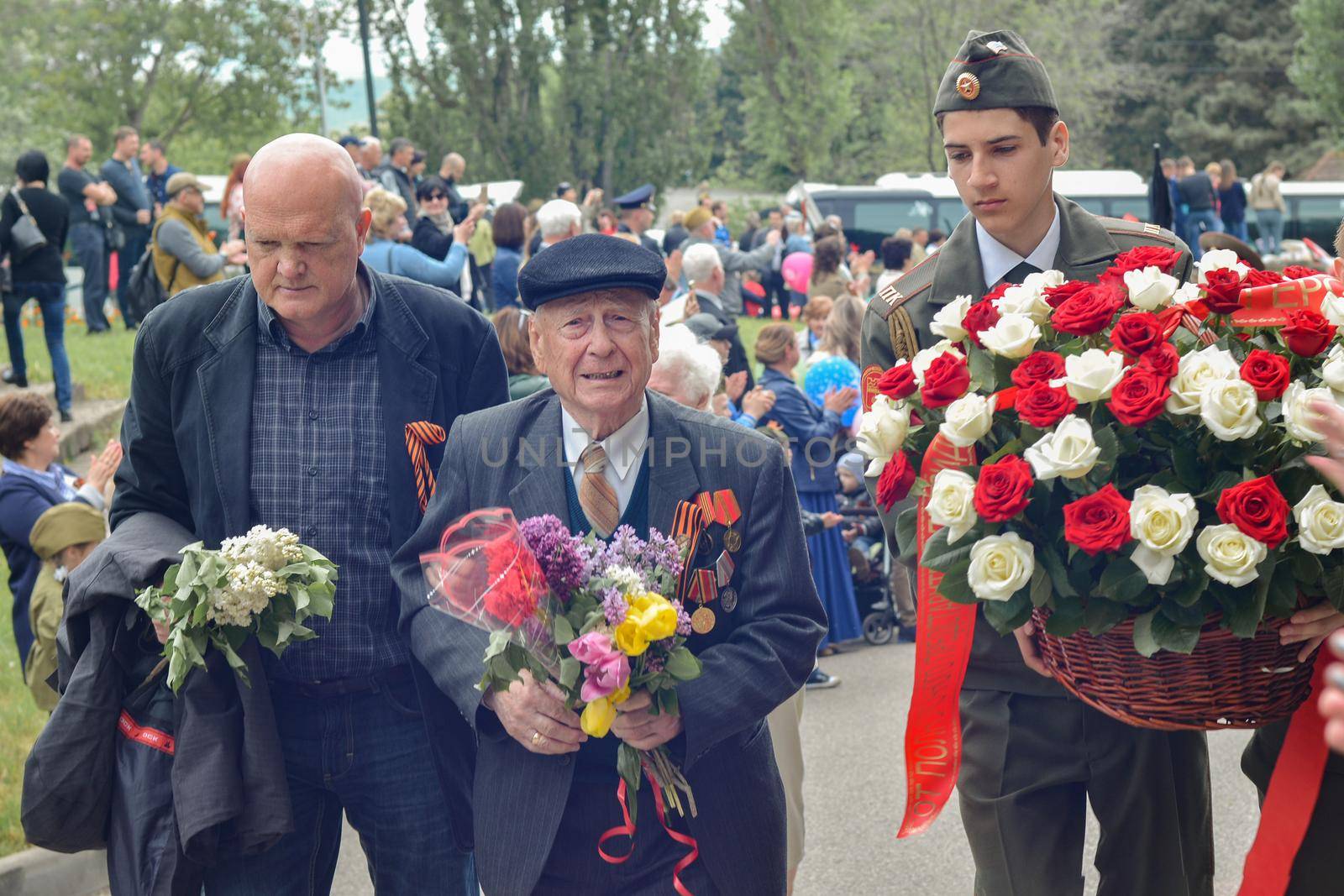 PYATIGORSK, RUSSIA - MAY 09, 2017: Carer and elderly man with a walking stick on Victory Day