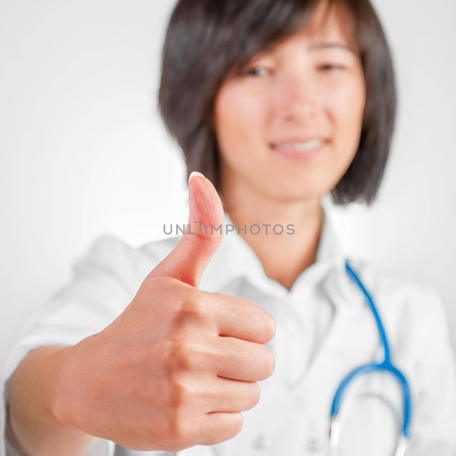 Portrait of woman doctor showing thumbs up sign