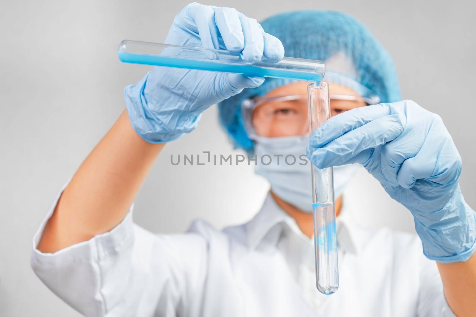 Laboratory female technician transfusions liquid from the flask