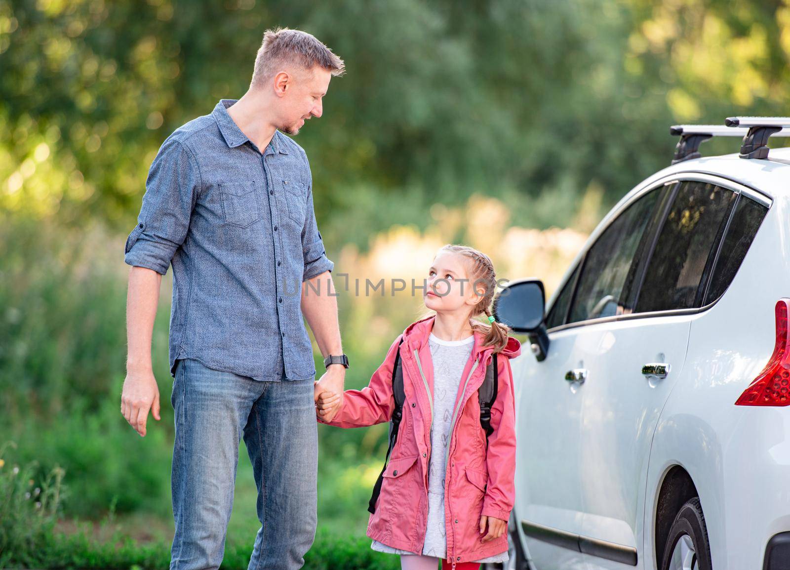 Little girl going back to school holding hands with father