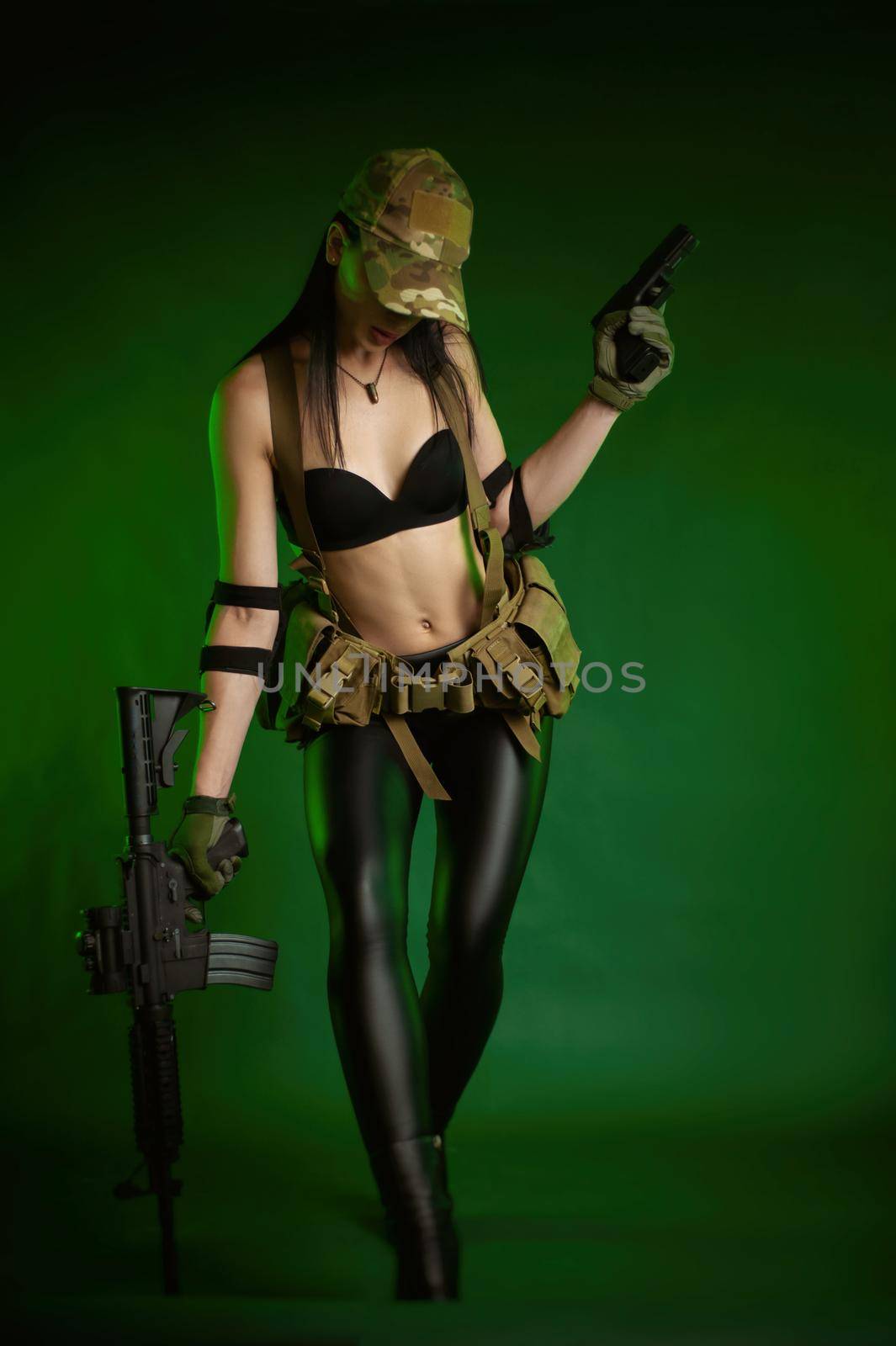 slender woman in military fatigues with an American automatic rifle on a green background by Rotozey