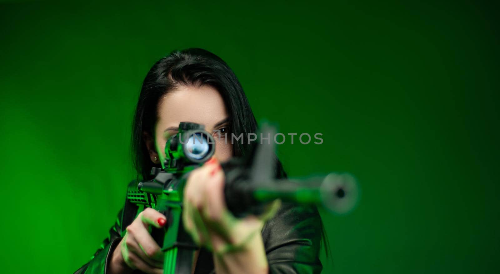 a woman in a black leather raincoat with an American automatic rifle on a green background by Rotozey