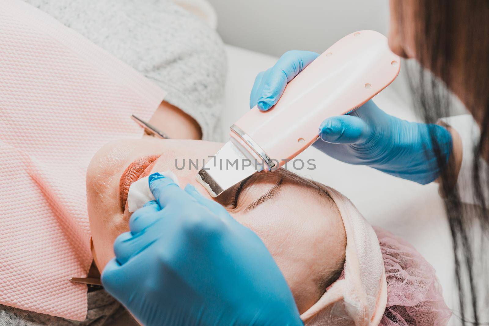 Moisturizing the face and removing keratinized old skin, the beautician uses ultrasound with microvibrations. new