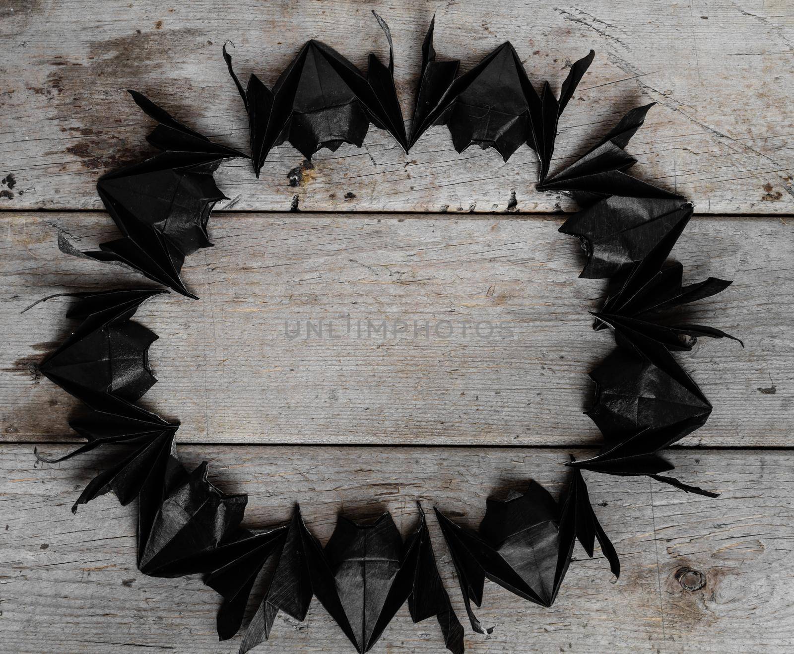 Frame from origami bats on the background wooden
