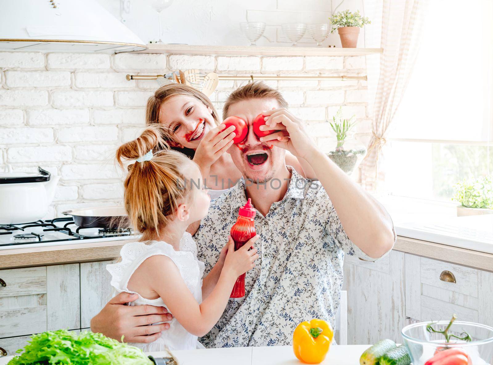 dad with two little daughters preparing pizza in the kitchen