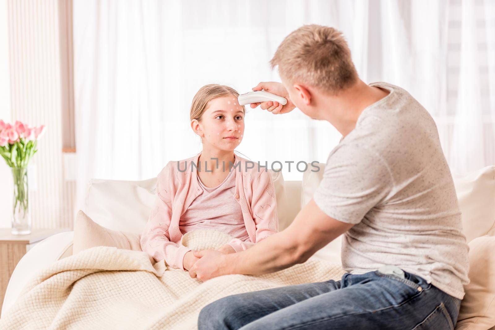 Caring dad using modern electric thermometer on sick of chickenpox girl