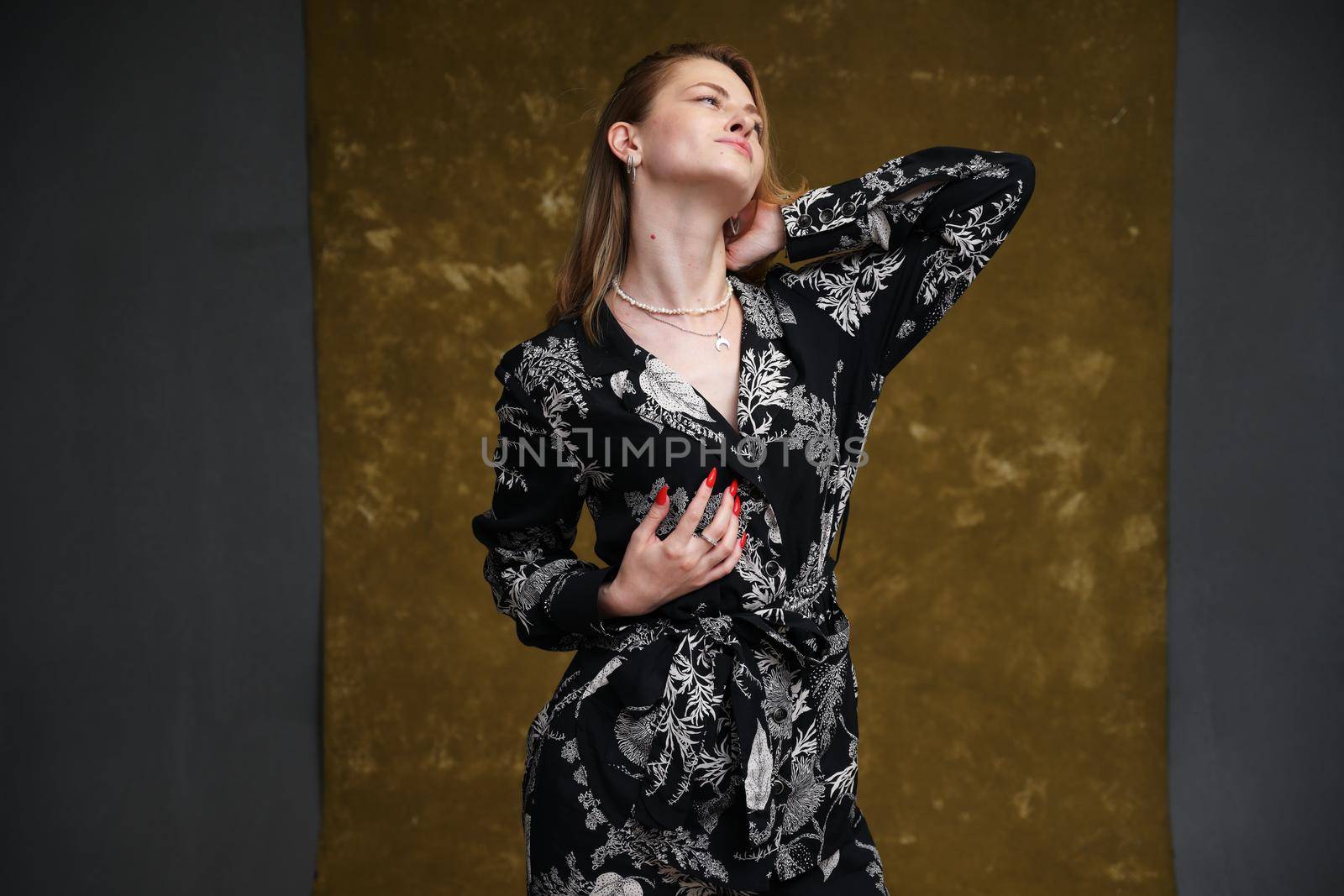 fashion photo model posing on dark beige background in studio by chichaevstudio