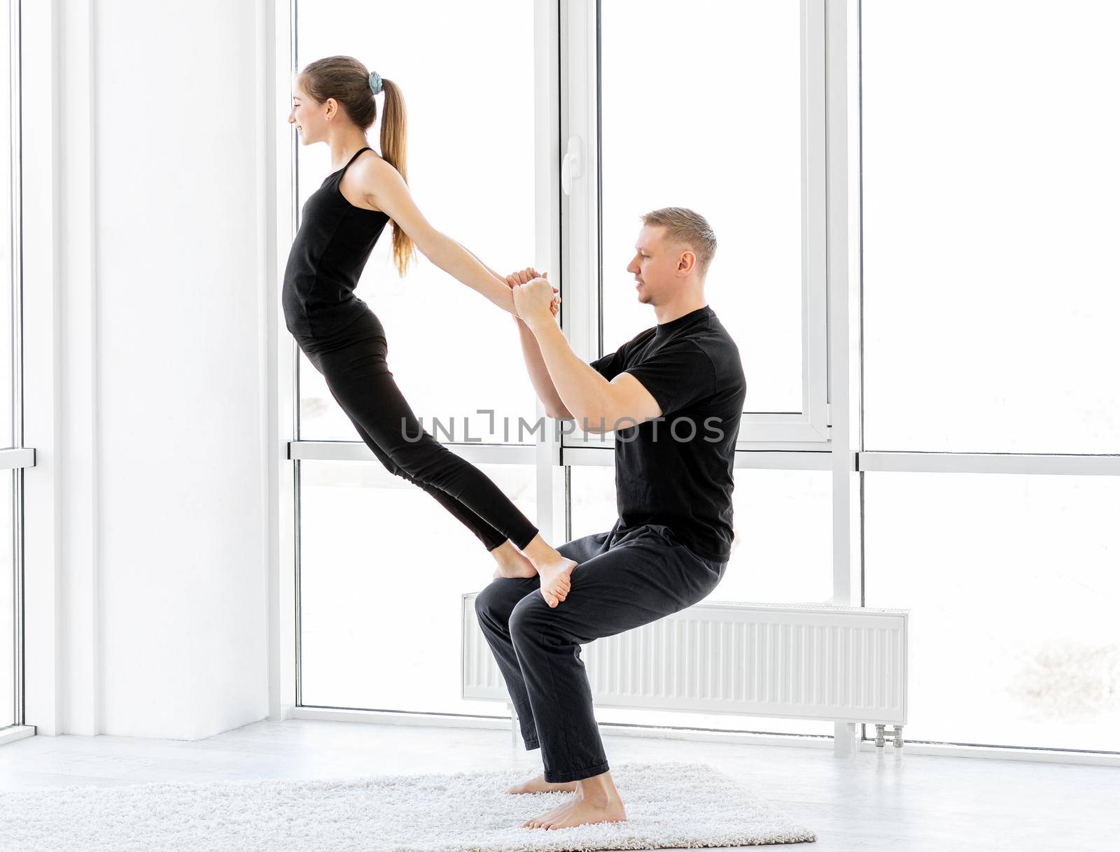 Beautiful athletes performing gymnastic exercises indoors