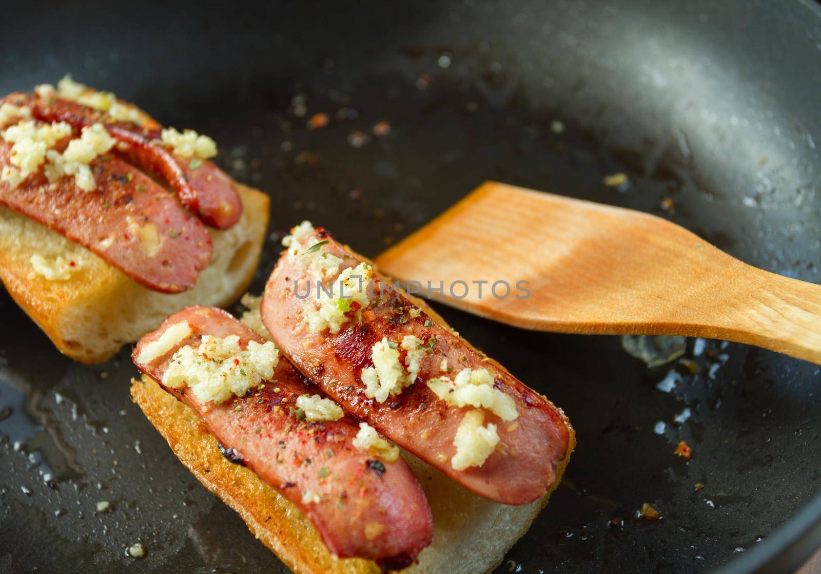 Fried bread with sausage and spices in a pan