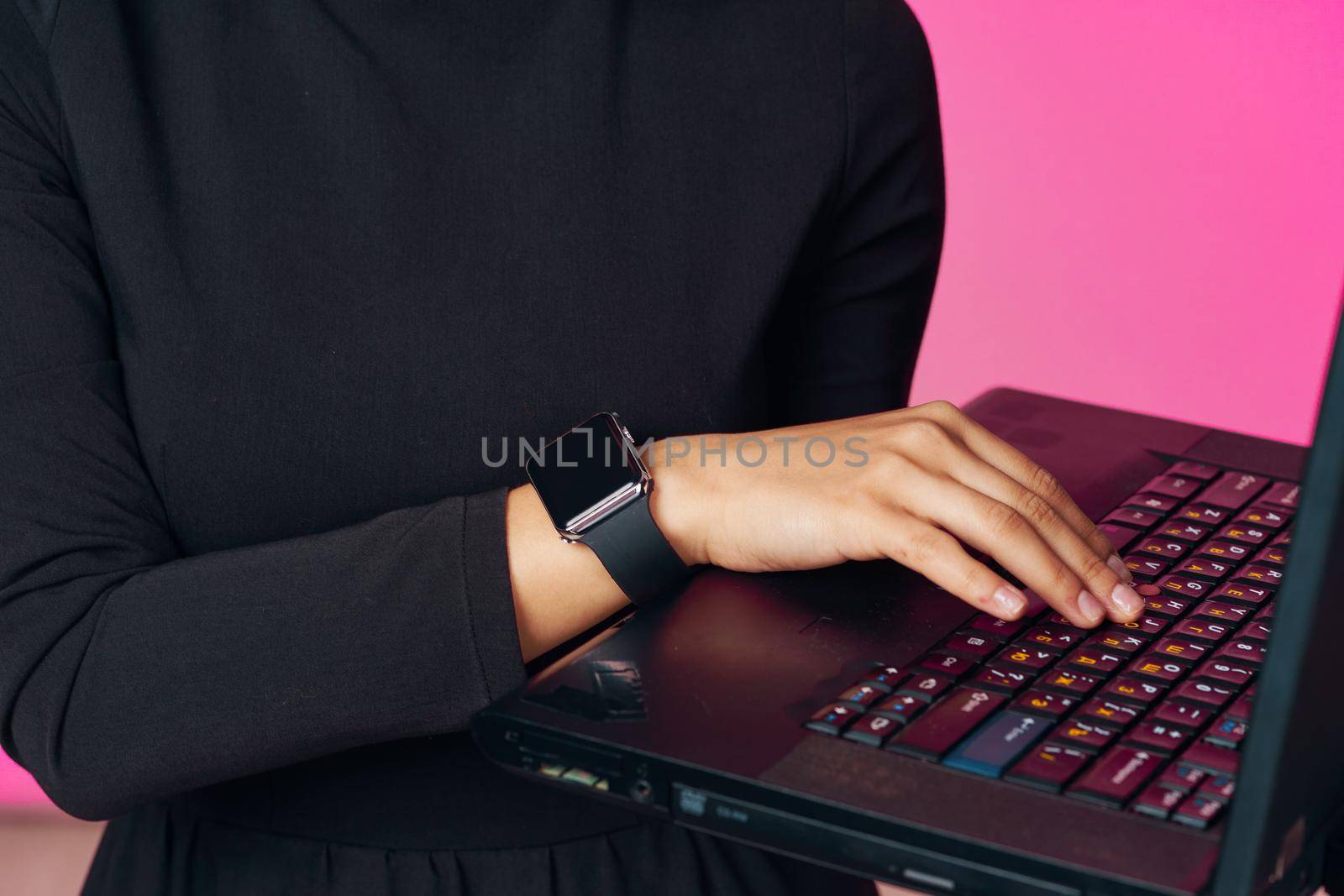 muslim woman in hijab with laptop technology learning pink background. High quality photo