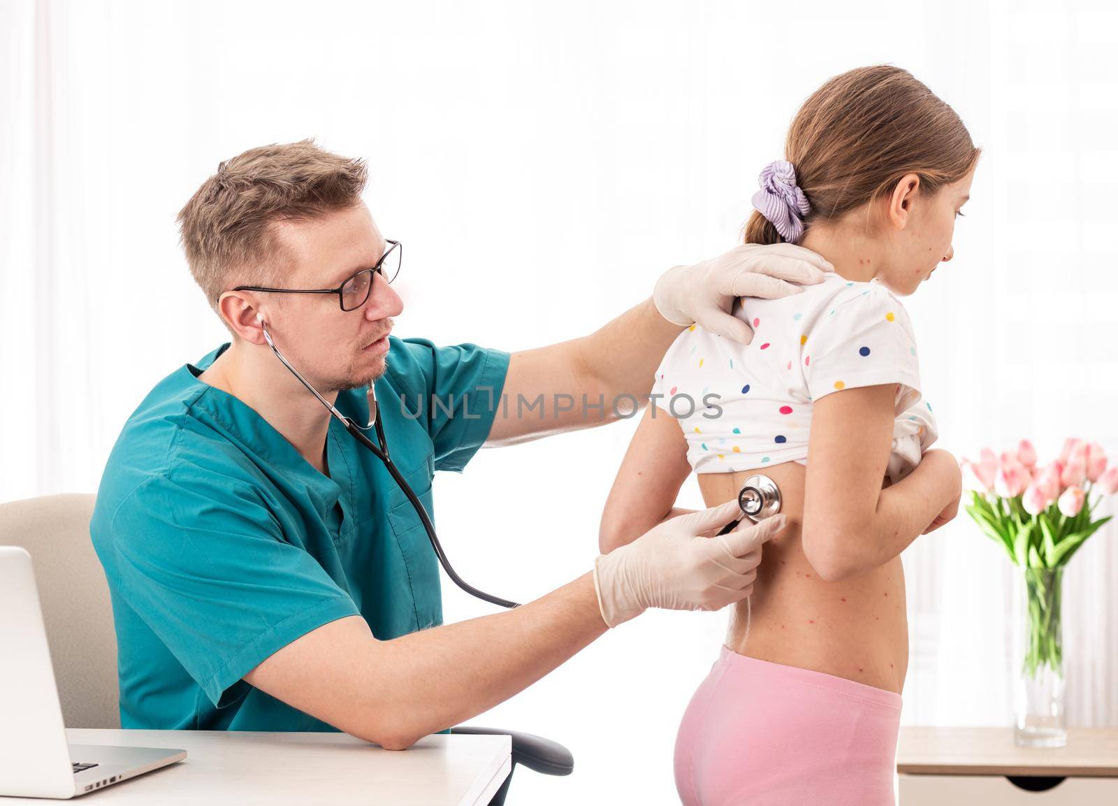 Doctor in the uniformm checking health status of a girl with stethoscope, on white background