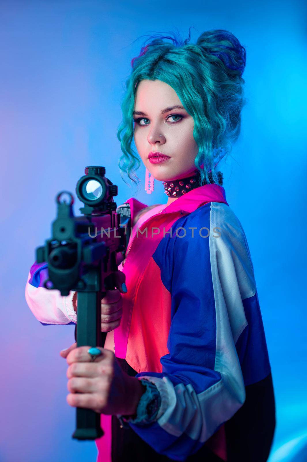 the bright female hooligan in a tracksuit with an automatic rifle in the bright neon light