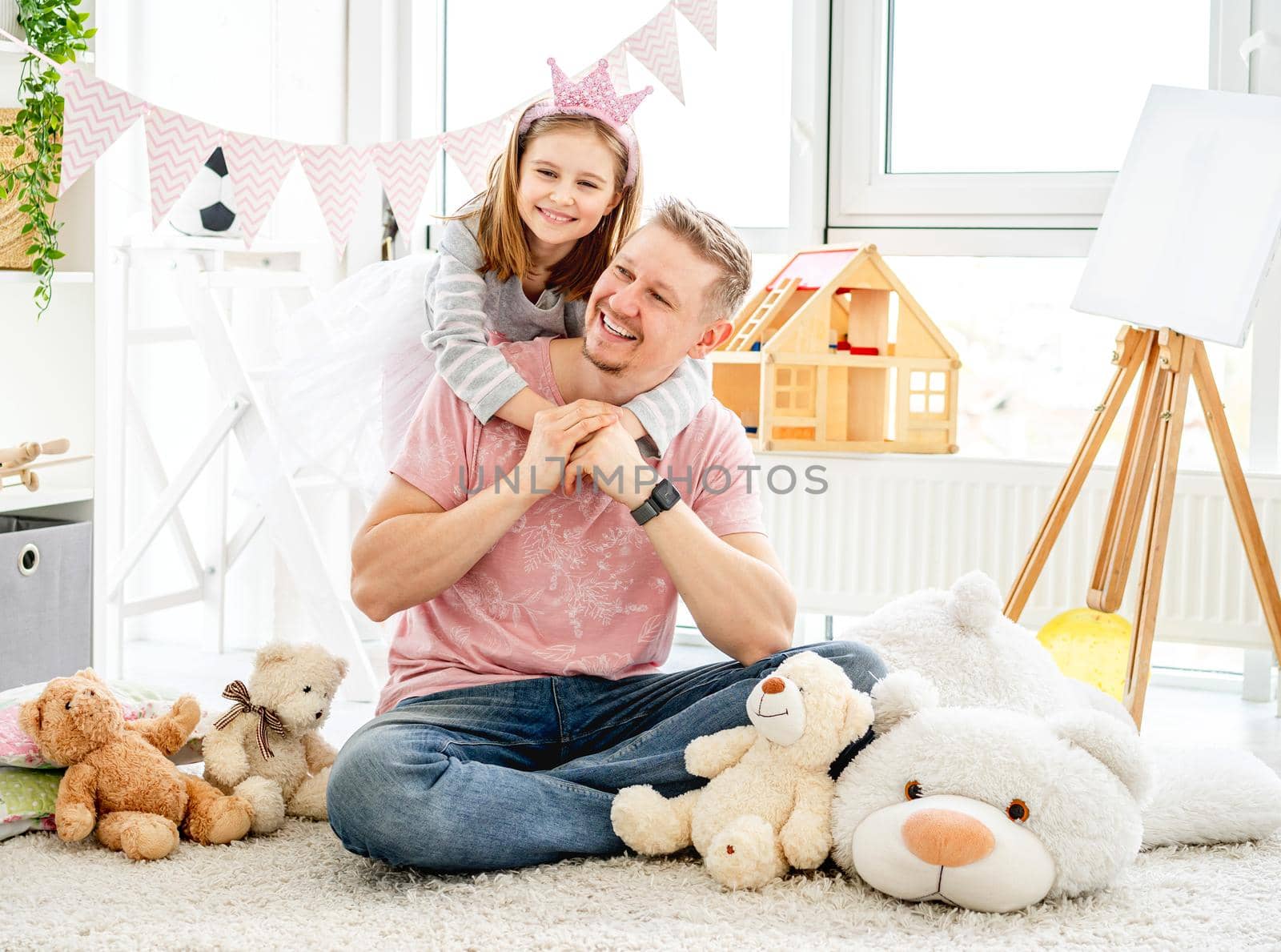 Smiling father and happy daughter spending time together in decorated room