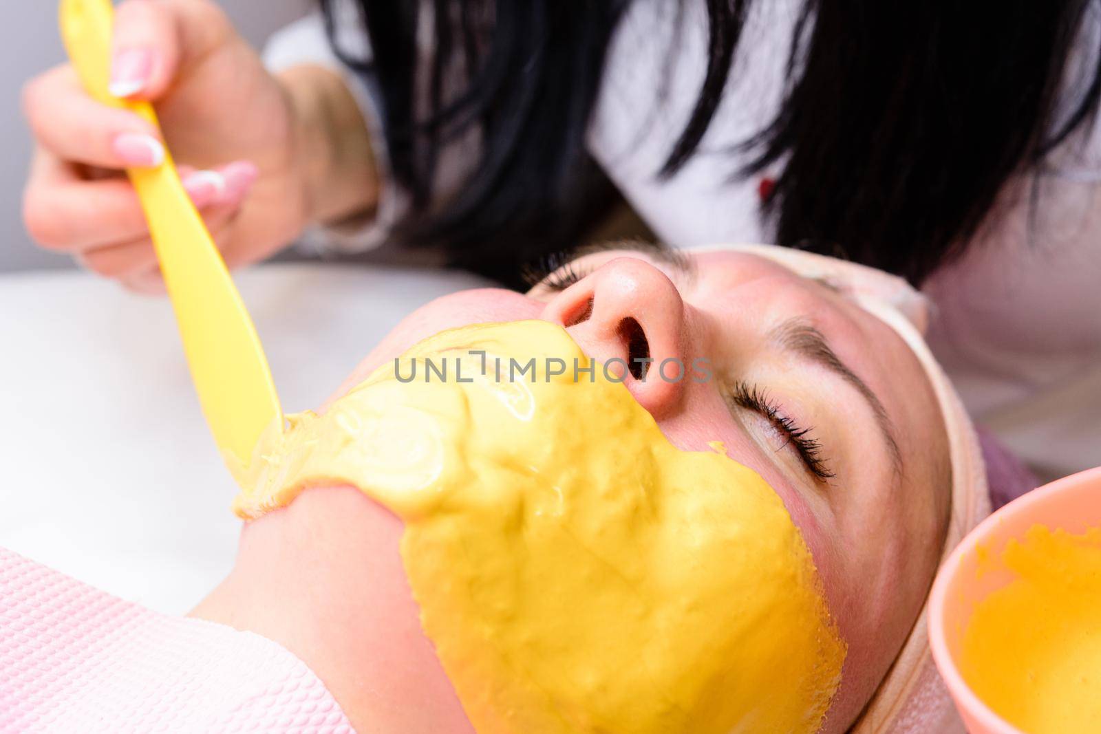 Applying a golden mask on the face after the cleansing procedure, an aromatic mask to moisturize, rejuvenate and lighten the skin. new