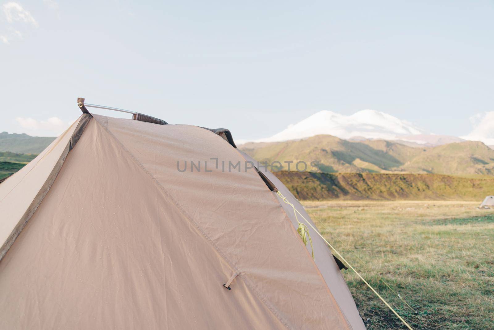 Camping hiking tent on background of Elbrus mountain in summer.