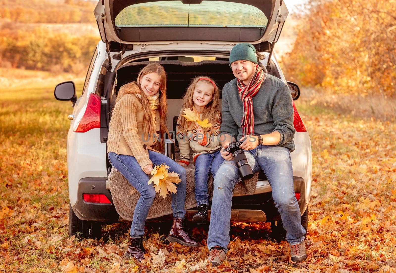 Smiling father with daughters in autumn surroundings