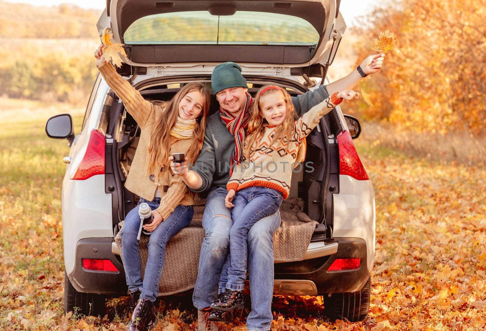 Smiling father with daughters in autumn surroundings