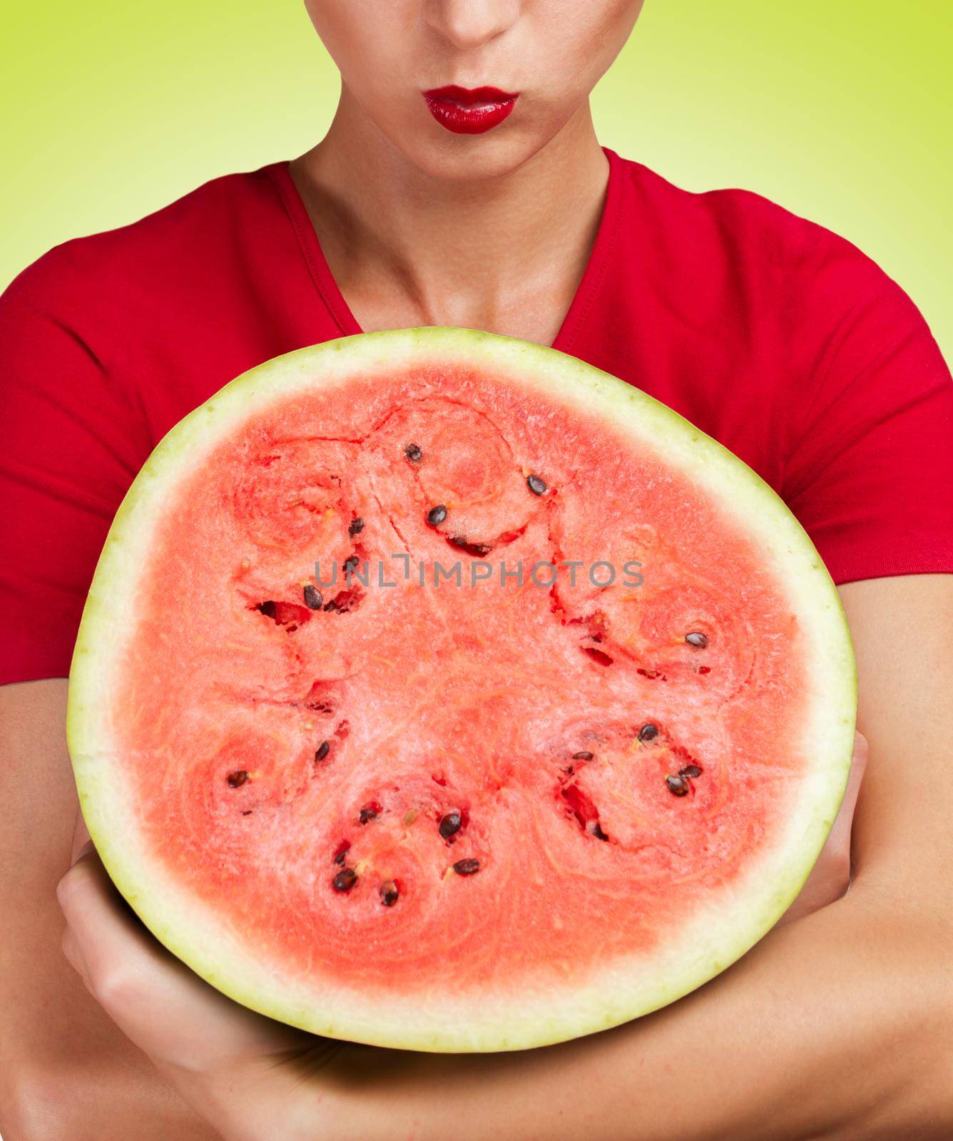 Young woman hugs a round half a watermelon