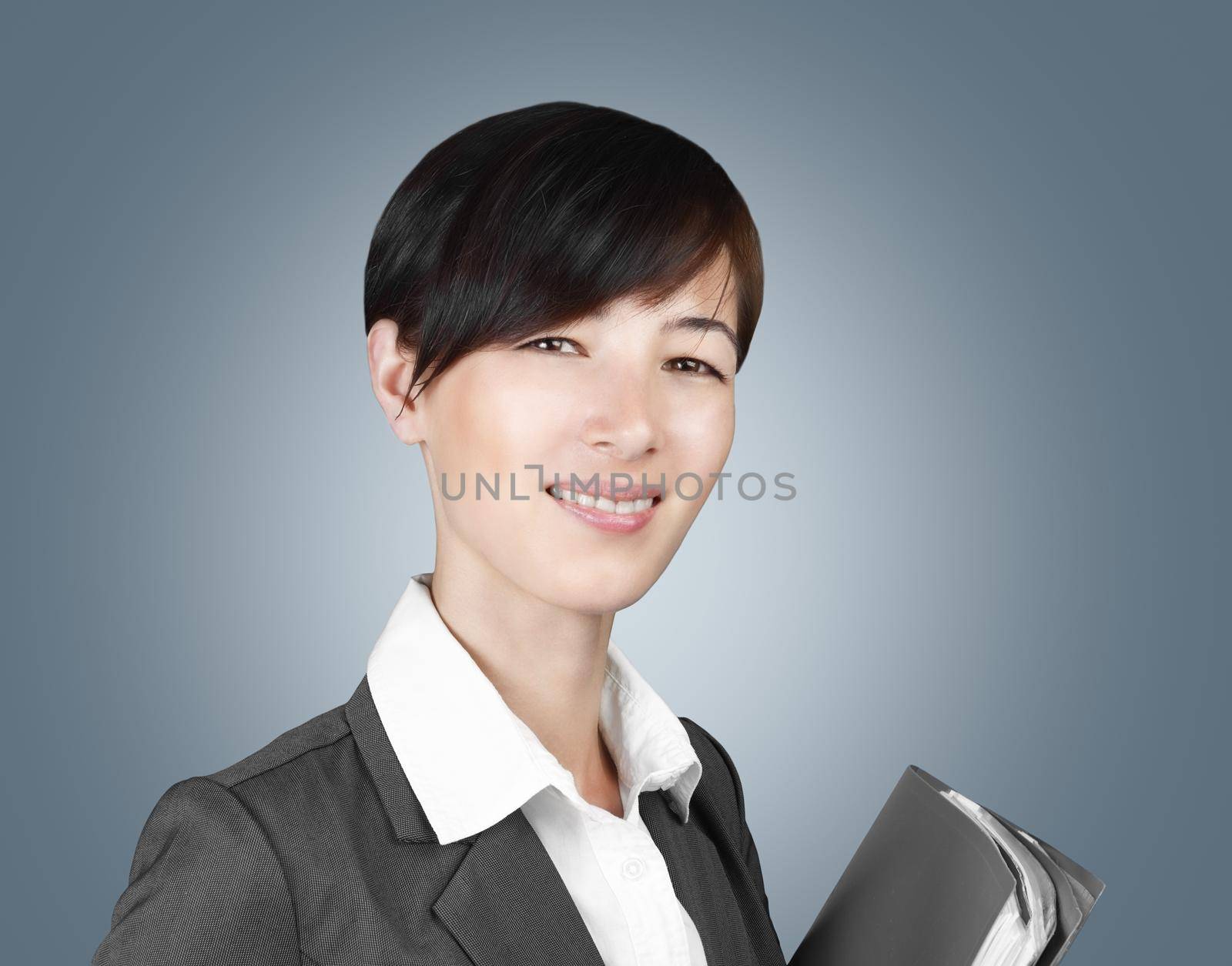 Young smiling woman in a suit with a folder in hands on a gray background