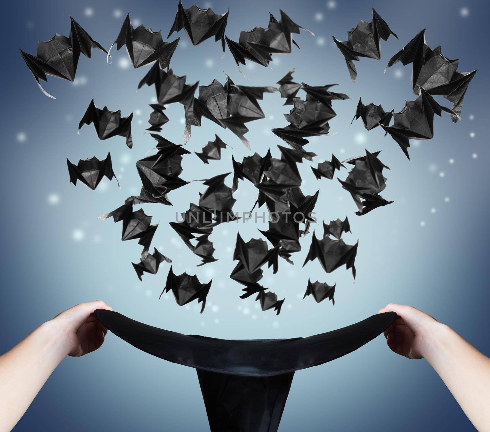 Halloween origami bats fly out of the hat