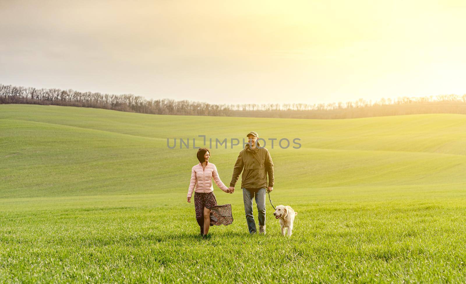 Couple walking dog on spring field by tan4ikk1