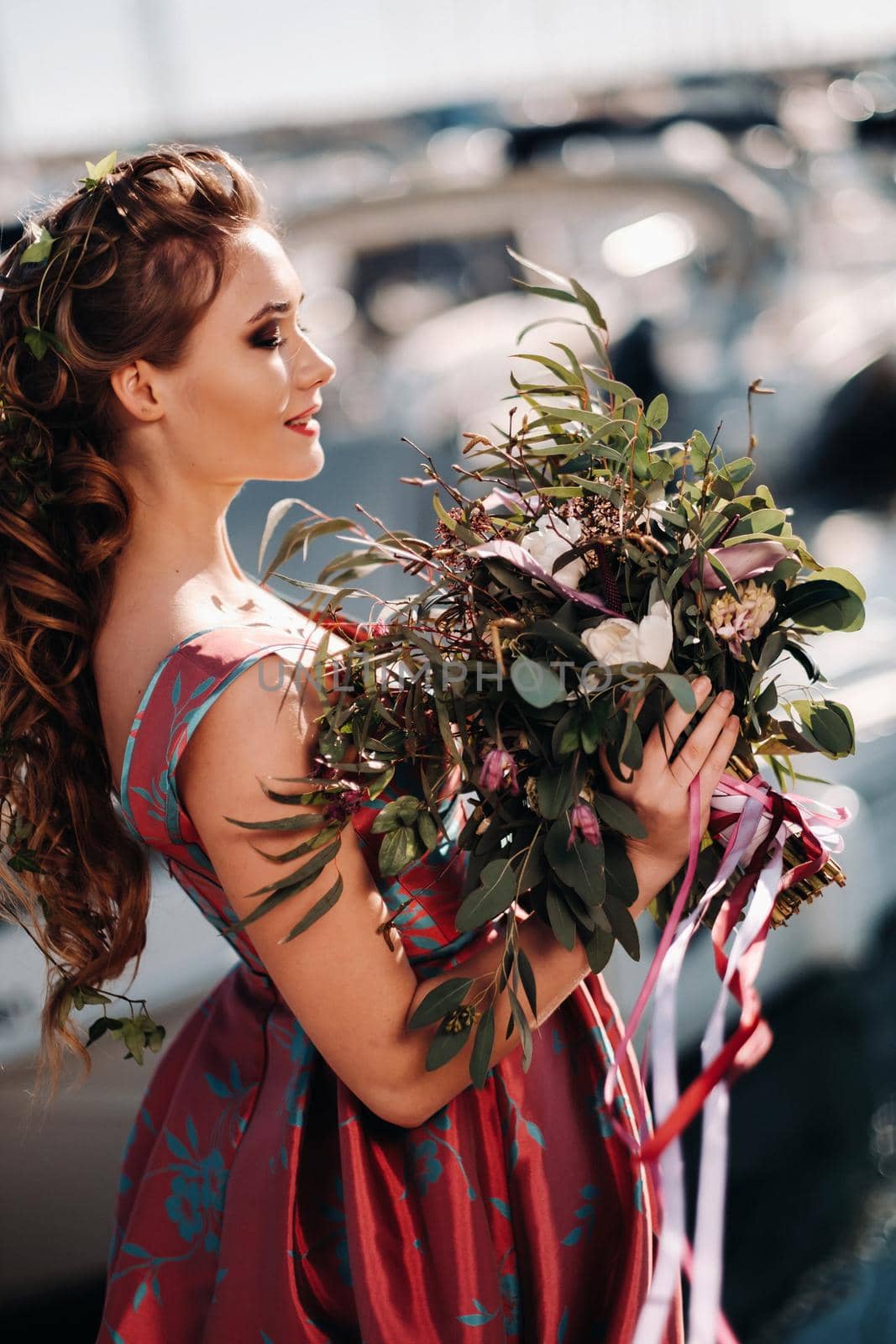 Young model girl in a beautiful dress with a bouquet of flowers on the beach in France. Girl with flowers in spring Provence on the French Riviera.