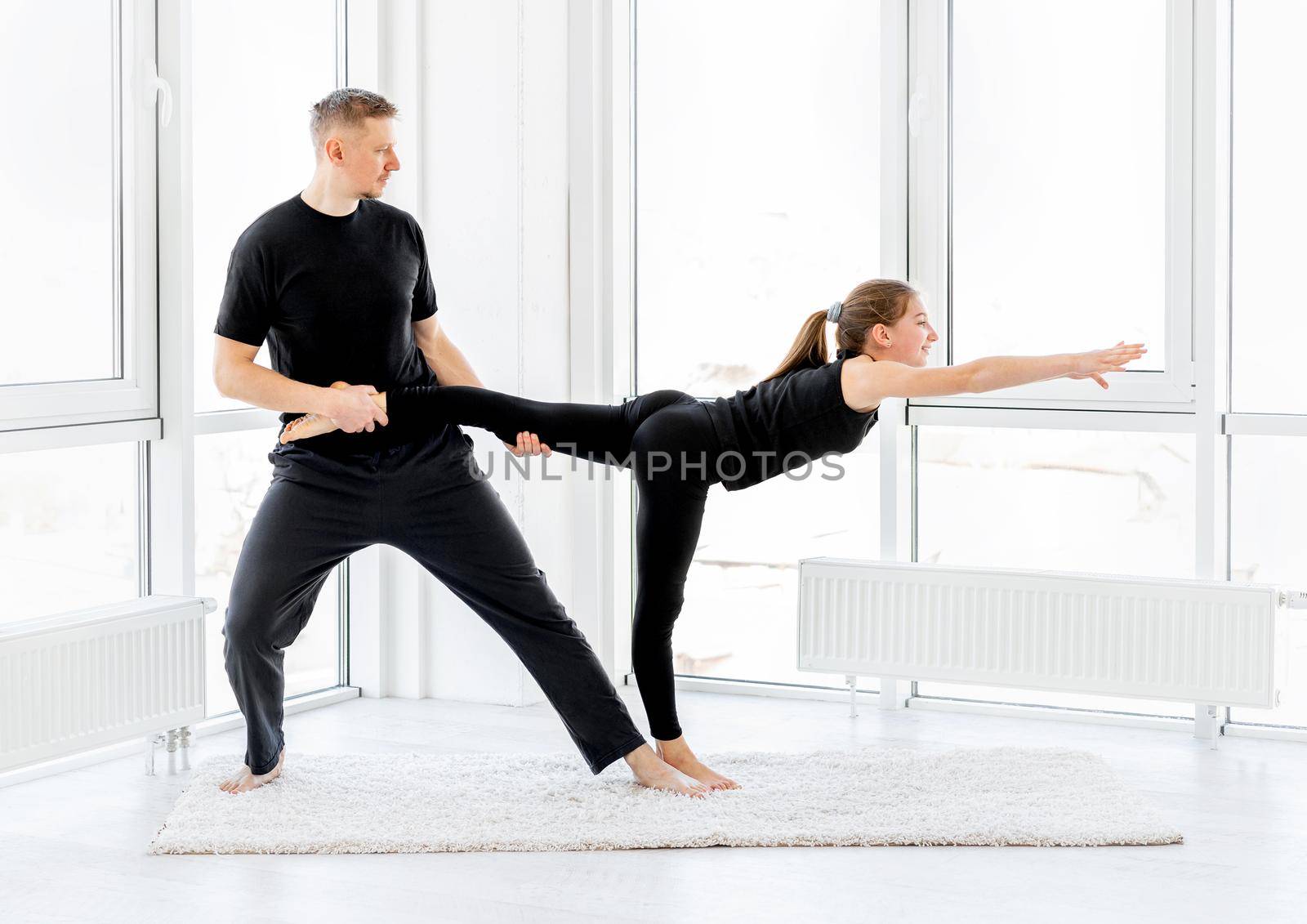 Cute girl and man doing workout in light gym