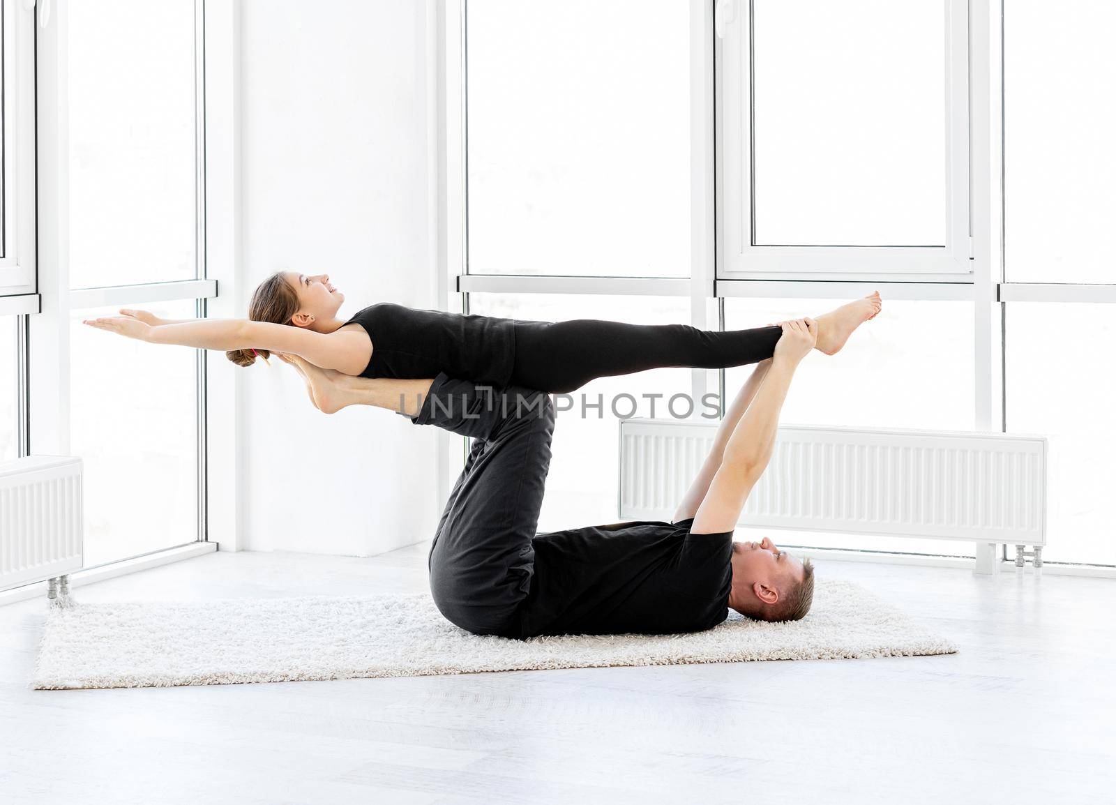 Sporty couple exercising acrobatics indoors