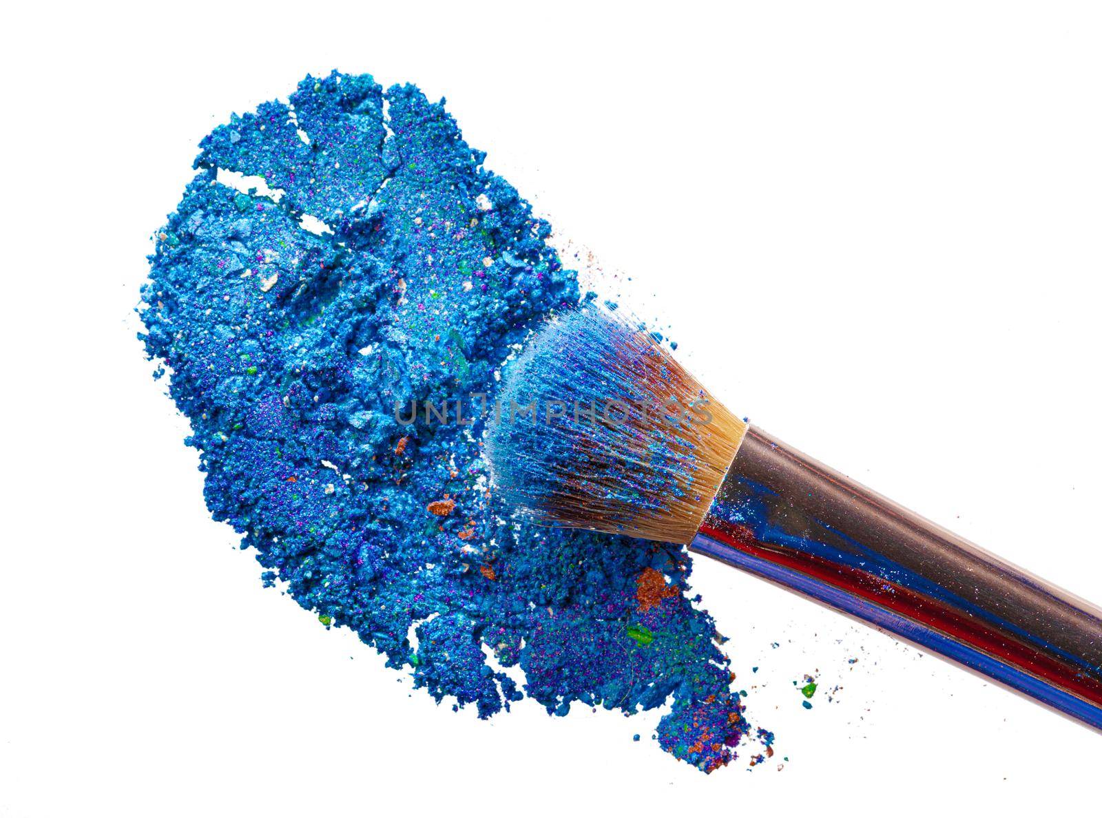 Crushed eyeshadows with brush isolated on white background. Close up.