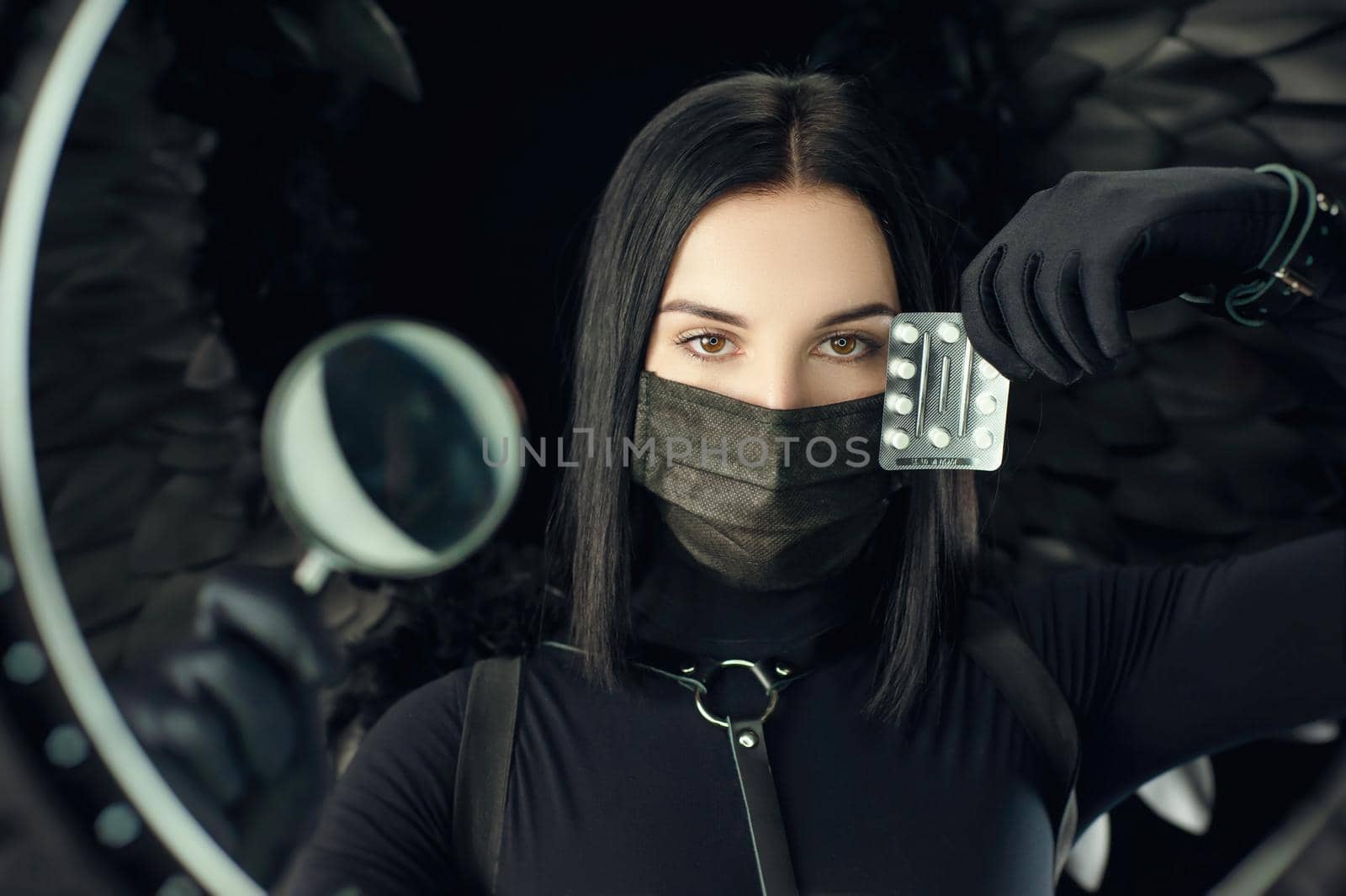 brunette wearing a protective black coronavirus mask with pills and a magnifying glass by Rotozey