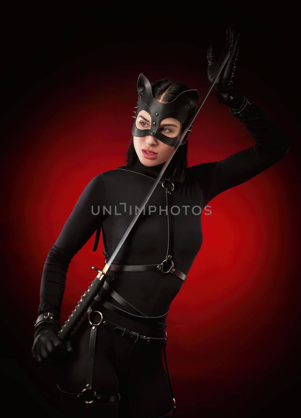 the woman in a black belt and cat mask with a katana