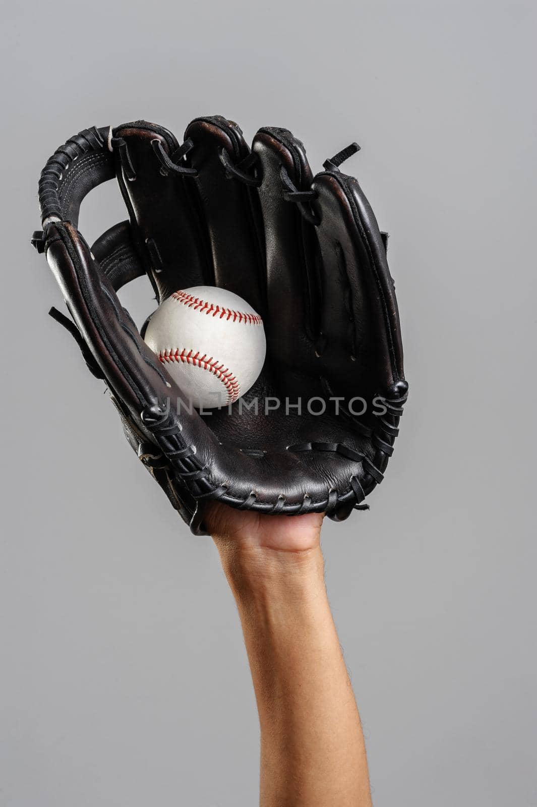 catching baseball with leather baseball glove over gray background