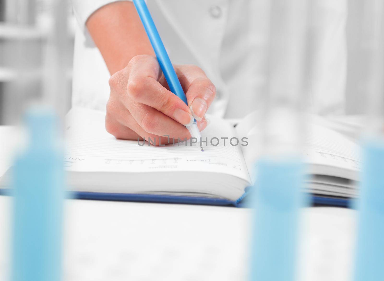 Lab technician writes the results of successful research into the notebook