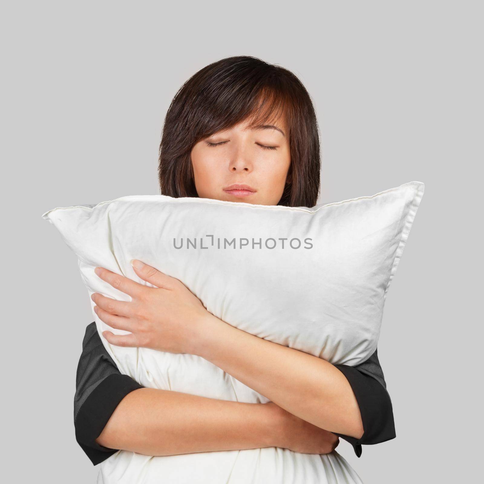 Young woman hugging a pillow. The concept of a tired business worker