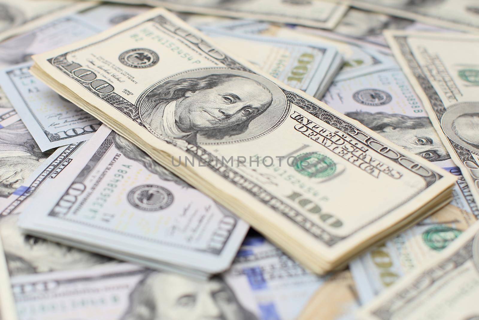 Heap of one hundred dollar bills on money background. Shallow depth field. Selective focus. by Maximusnd