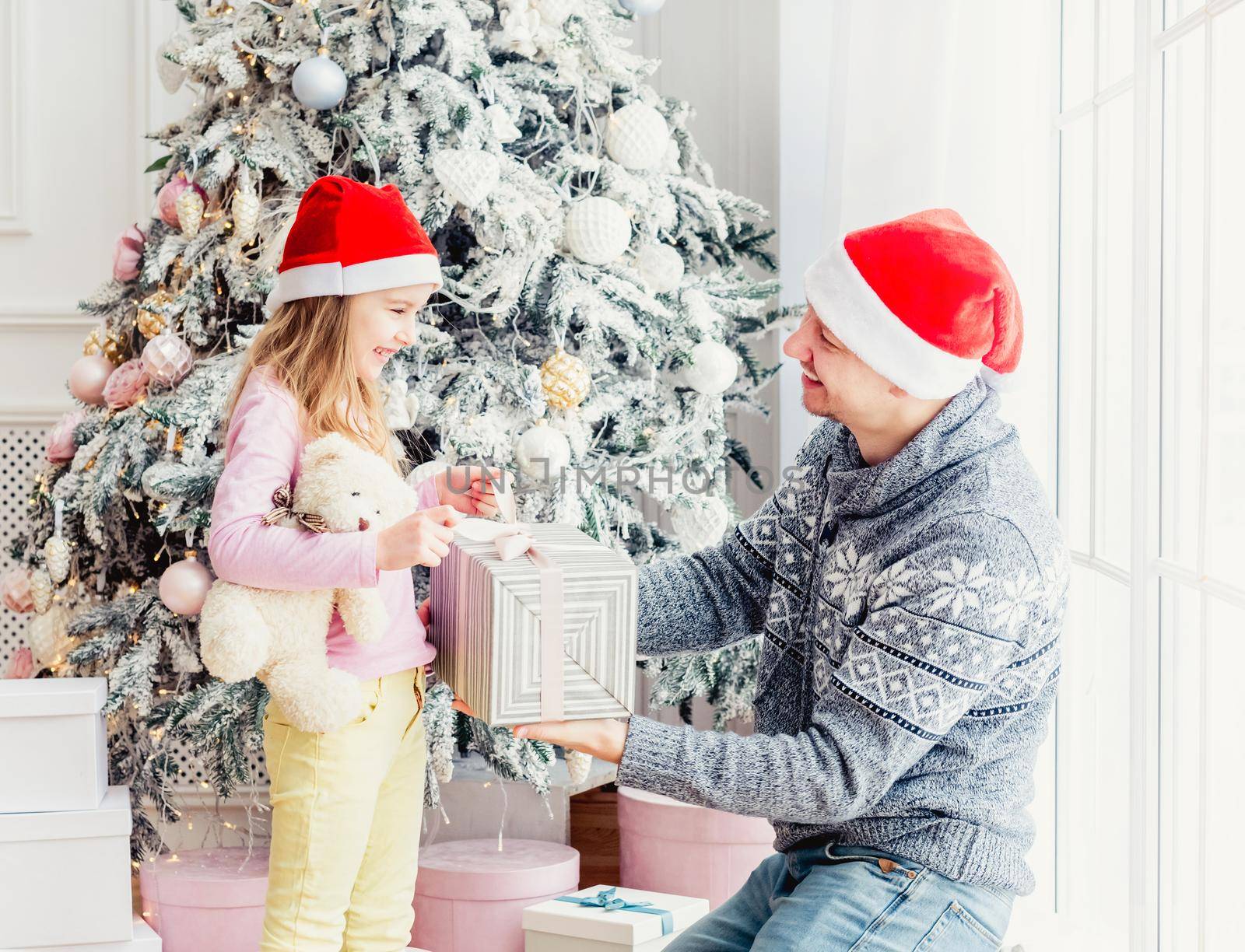 Smiling father giving little daughter christmas gift