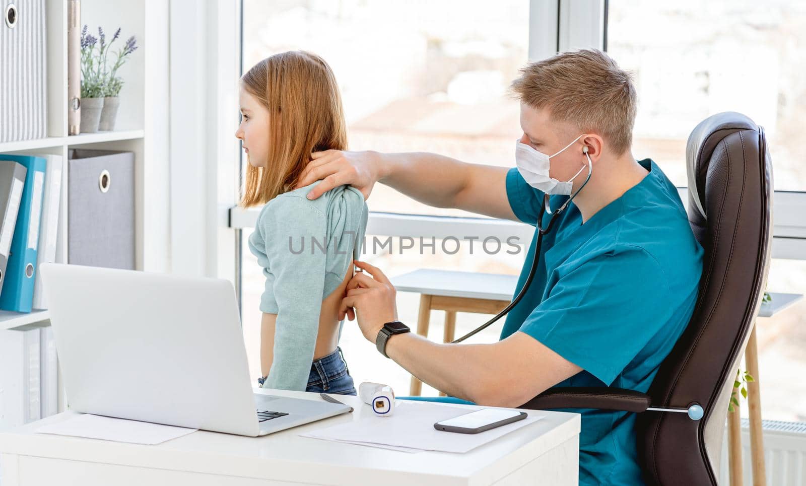 Doctor listening little girl by phonendoscope in clinic