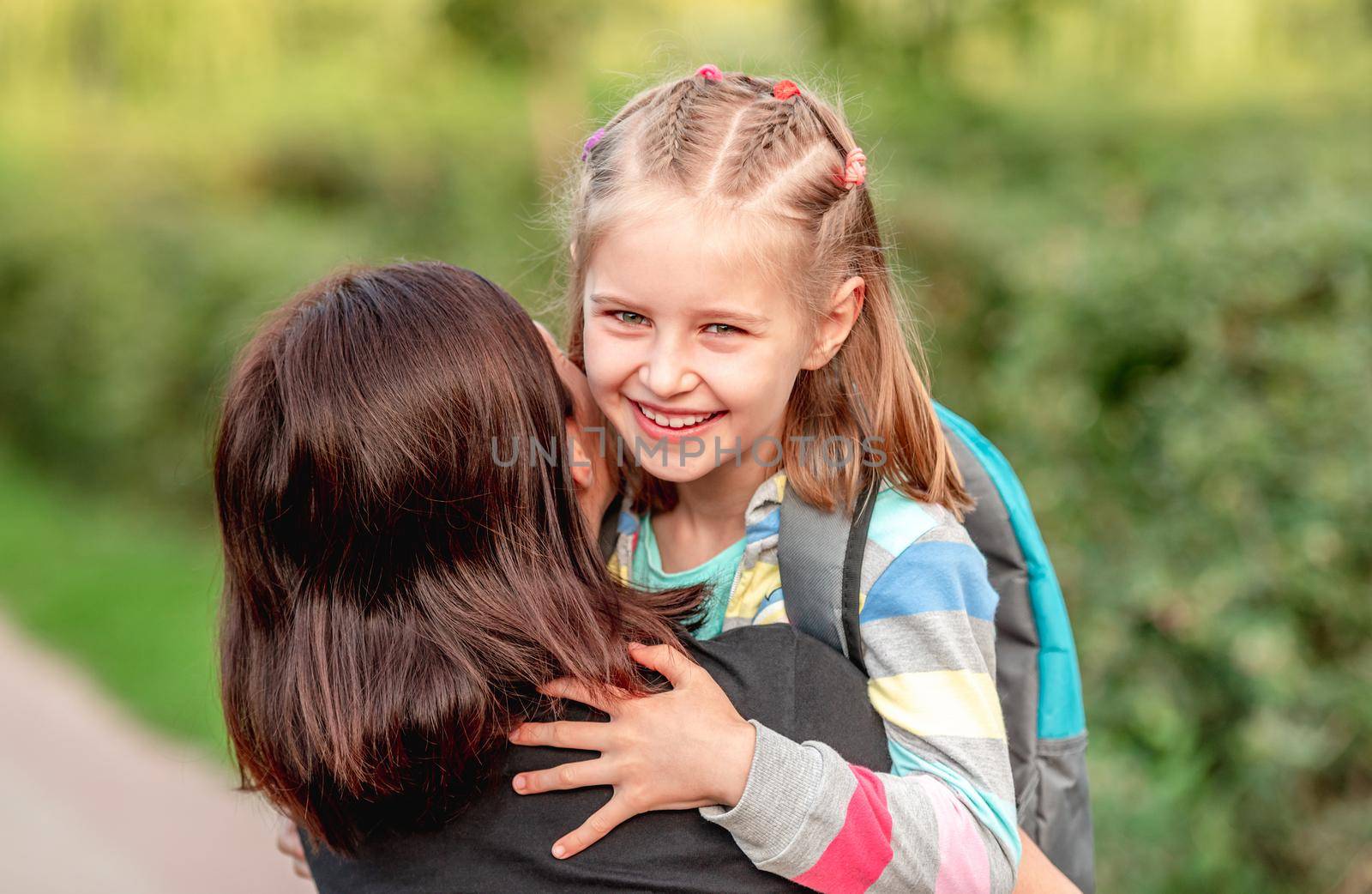 School girl hugging mother after classes by tan4ikk1